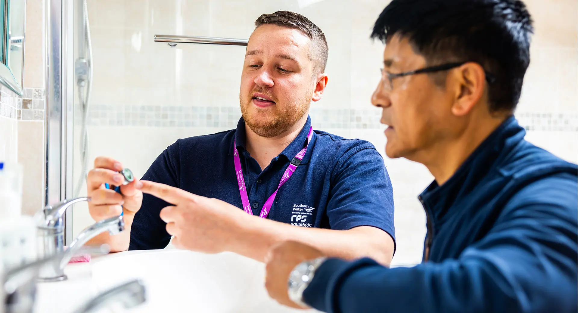 Workers discussing part of a sink