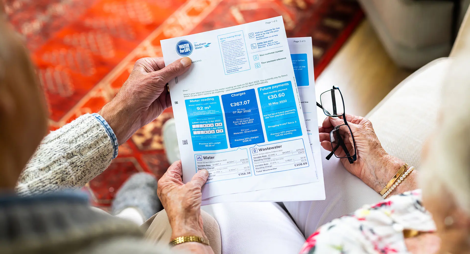 Two elderly people reading their water bill